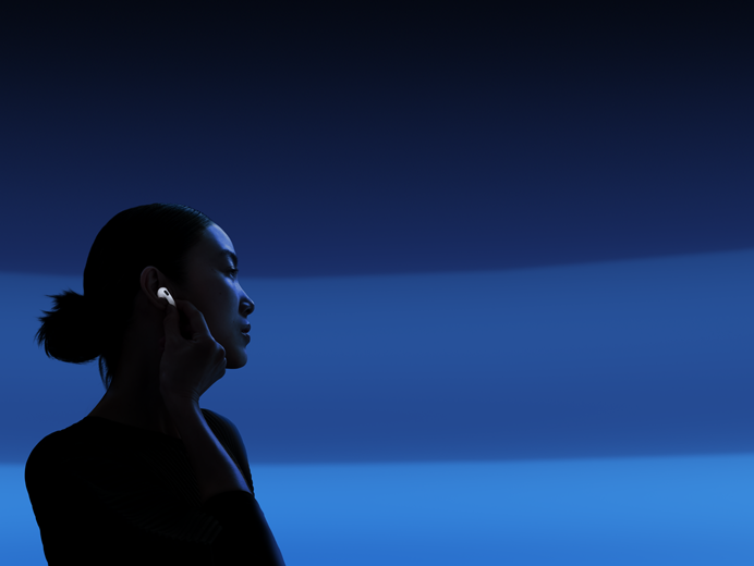 Une personne tenant la tige de ses AirPods 5 entre le pouce et l’index pour changer les modes d’écoute