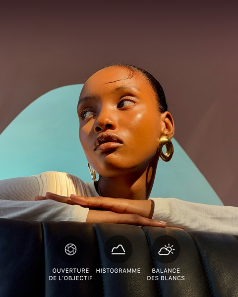 Portrait lumineux en gros plan d’une personne sur un fond coloré, illustrant l’interface des commandes Pro du système caméra pro : ouverture, histogramme, balance des blancs