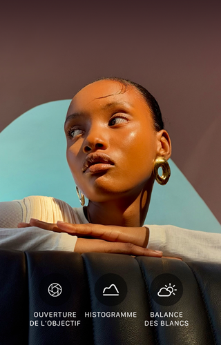 Portrait lumineux en gros plan d’une personne sur un fond coloré, illustrant l’interface des commandes Pro du système caméra pro : ouverture, histogramme, balance des blancs