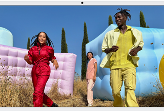 Trois personnes en tenues de couleurs vives entourées de formes gonflables colorées