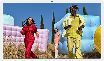 Trois personnes en tenues de couleurs vives entourées de formes gonflables colorées