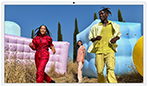 Trois personnes en tenues de couleurs vives entourées de formes gonflables colorées